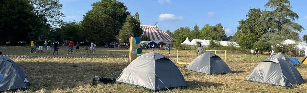 Photo du camp : tentes des jeunes au premier plan et le grand chapiteau où avaient lieu les cultes matinaux au dernier plan
